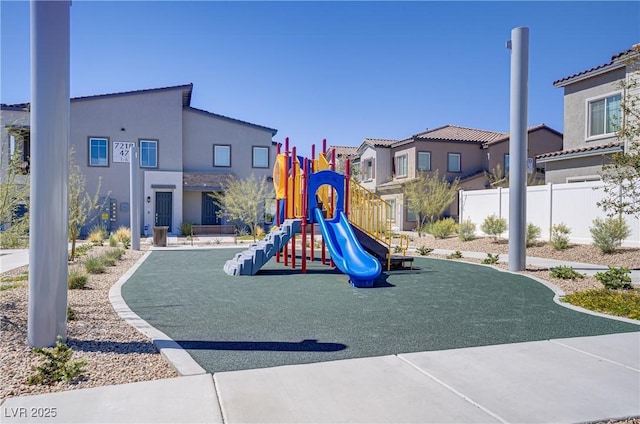community playground with fence and a residential view