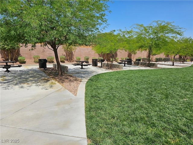 view of property's community with a yard, fence, and a patio