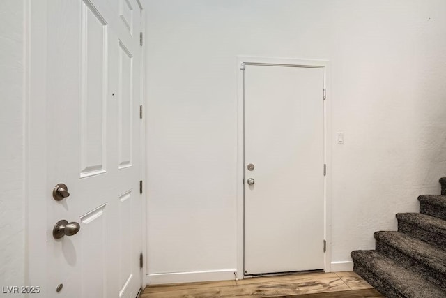 entrance foyer with stairway, light wood finished floors, and baseboards