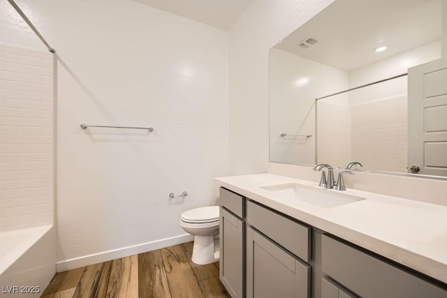 bathroom featuring toilet, baseboards, visible vents, vanity, and wood finished floors