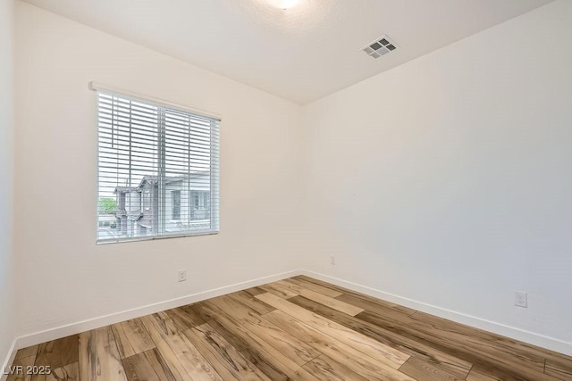 unfurnished room featuring visible vents, baseboards, and light wood-style flooring