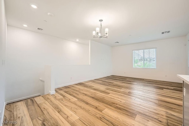 unfurnished room with light wood-type flooring, recessed lighting, a chandelier, and visible vents