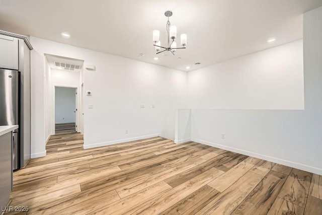 unfurnished dining area featuring an inviting chandelier, light wood-style flooring, visible vents, baseboards, and recessed lighting