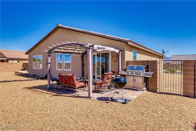 rear view of property with stucco siding, a pergola, a patio, and fence