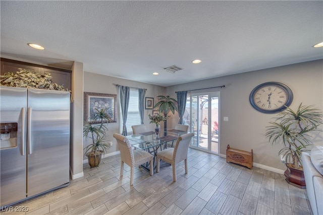 dining space featuring wood finish floors, visible vents, baseboards, and a wealth of natural light