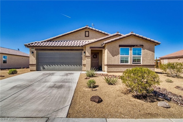 view of front of home featuring stucco siding, a garage, driveway, and a tiled roof