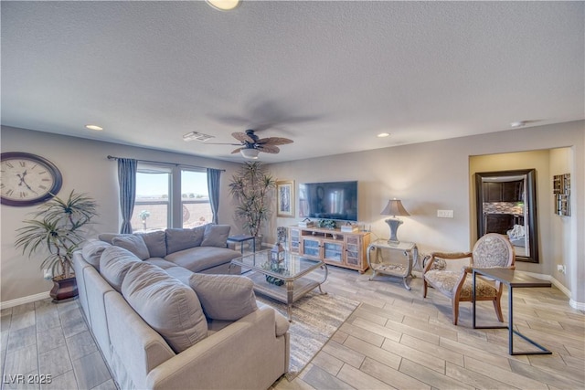 living room with baseboards, visible vents, wood finish floors, ceiling fan, and a textured ceiling