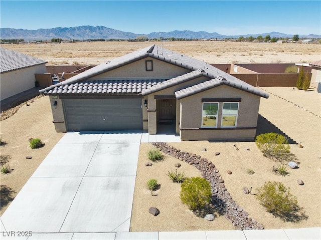 single story home with driveway, stucco siding, a garage, a tiled roof, and a mountain view
