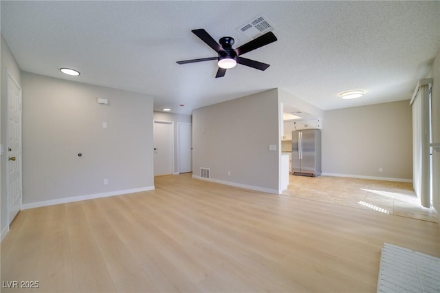 6649 W Tropicana Ave Unit 101, Las Vegas, NV 89103 - unfurnished living room featuring a ceiling fan, light wood finished floors, and baseboards