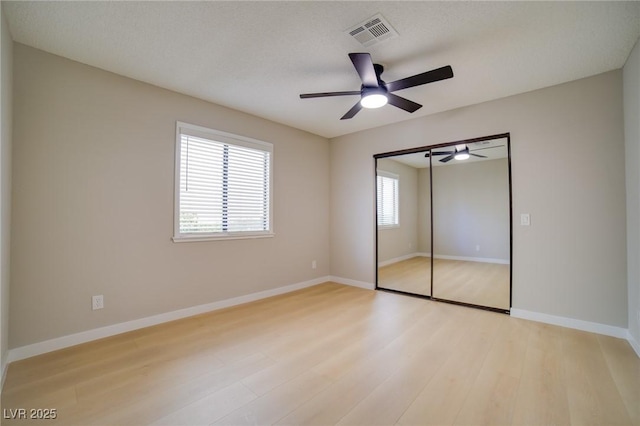 6649 W Tropicana Ave Unit 101, Las Vegas, NV 89103 - unfurnished bedroom featuring light wood-type flooring, multiple windows, and baseboards