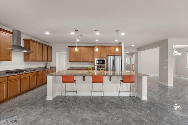 kitchen featuring brown cabinetry, a breakfast bar area, a spacious island, wall chimney range hood, and stainless steel appliances