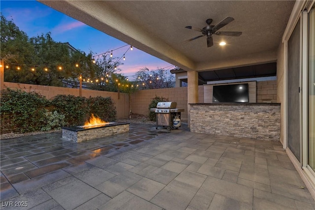 view of patio / terrace featuring ceiling fan, grilling area, area for grilling, a fenced backyard, and a fire pit