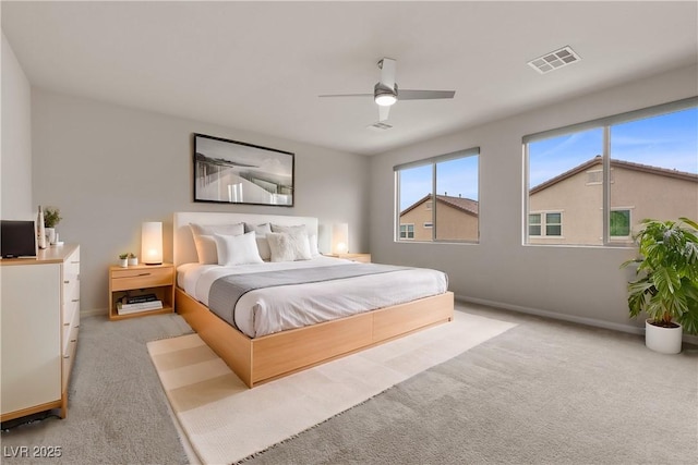 bedroom featuring light colored carpet, baseboards, visible vents, and a ceiling fan
