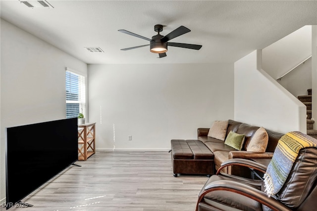 3725 Celesta Vista Ave, Henderson, NV 89044 - living room with light wood-type flooring, a ceiling fan, stairs, and baseboards