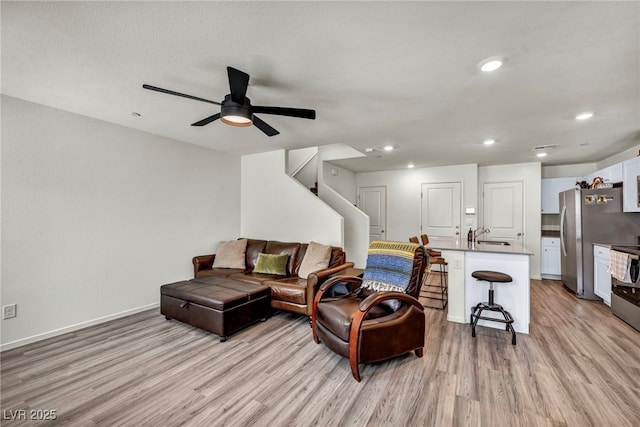 3725 Celesta Vista Ave, Henderson, NV 89044 - living room with light wood finished floors, a ceiling fan, recessed lighting, baseboards, and stairway