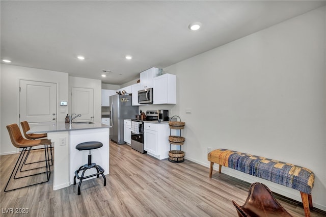 3725 Celesta Vista Ave, Henderson, NV 89044 - kitchen featuring stainless steel appliances, a sink, a breakfast bar, an island with sink, and baseboards