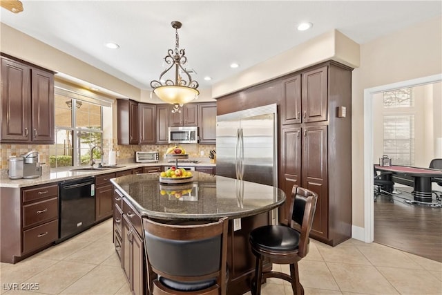 9517 Spanish Steps Ln, Las Vegas, NV 89117 - kitchen with appliances with stainless steel finishes, a sink, dark stone counters, decorative backsplash, and recessed lighting