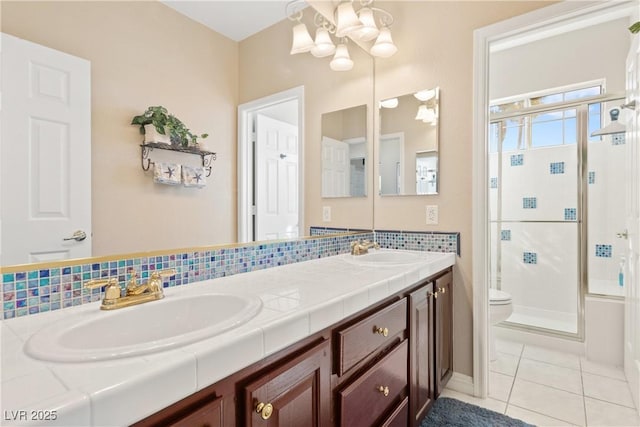 9517 Spanish Steps Ln, Las Vegas, NV 89117 - full bath with a stall shower, a chandelier, double vanity, tile patterned flooring, and toilet