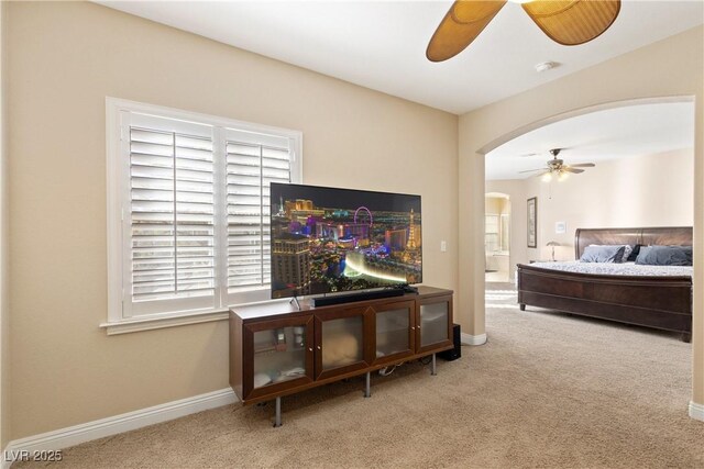 9517 Spanish Steps Ln, Las Vegas, NV 89117 - carpeted bedroom with arched walkways, multiple windows, baseboards, and a ceiling fan