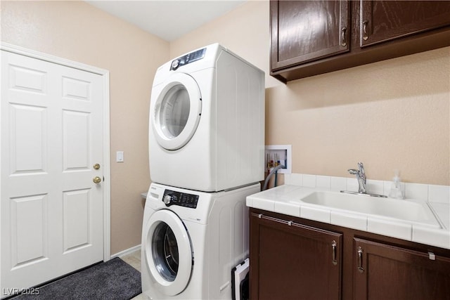 9517 Spanish Steps Ln, Las Vegas, NV 89117 - laundry room featuring stacked washer / drying machine, cabinet space, and baseboards