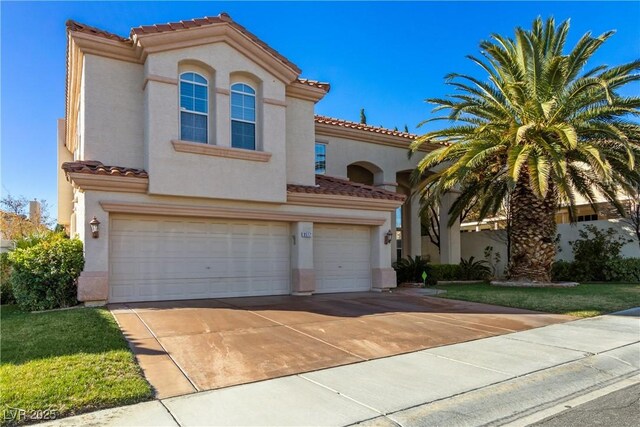 9517 Spanish Steps Ln, Las Vegas, NV 89117 - mediterranean / spanish home with a tiled roof, an attached garage, stucco siding, and driveway