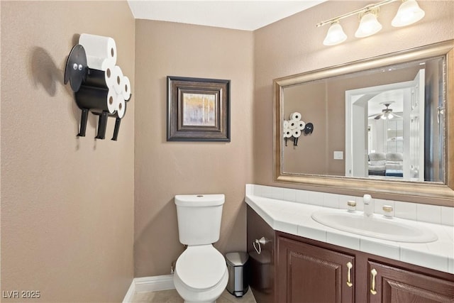 9517 Spanish Steps Ln, Las Vegas, NV 89117 - bathroom featuring vanity, toilet, a ceiling fan, and baseboards