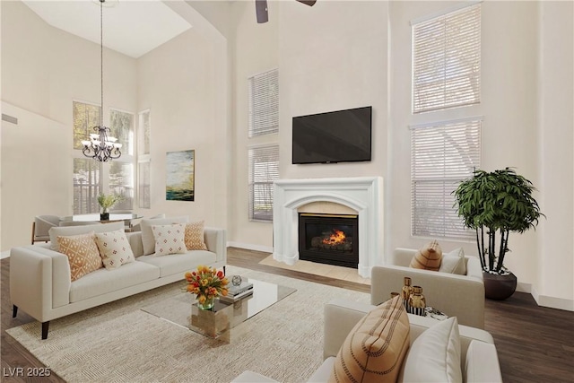 9517 Spanish Steps Ln, Las Vegas, NV 89117 - living room with a towering ceiling, baseboards, a ceiling fan, a fireplace with flush hearth, and wood finished floors