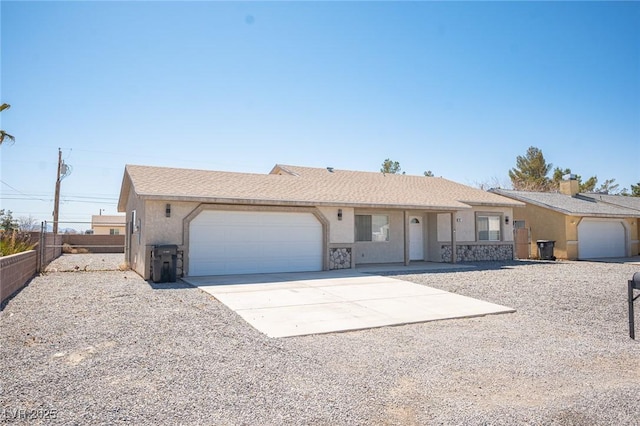 ranch-style house featuring concrete driveway, an attached garage, fence, and stucco siding