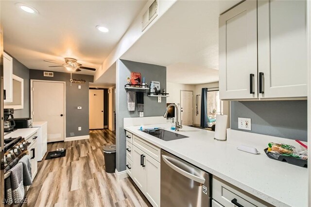 950 Seven Hills Dr Unit 814, Henderson, NV 89052 - kitchen with light countertops, stainless steel appliances, a ceiling fan, a sink, and light wood-type flooring