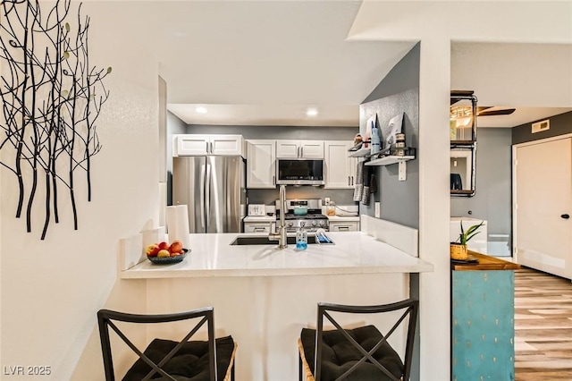 950 Seven Hills Dr Unit 814, Henderson, NV 89052 - kitchen with a kitchen bar, a peninsula, stainless steel appliances, and wood finished floors