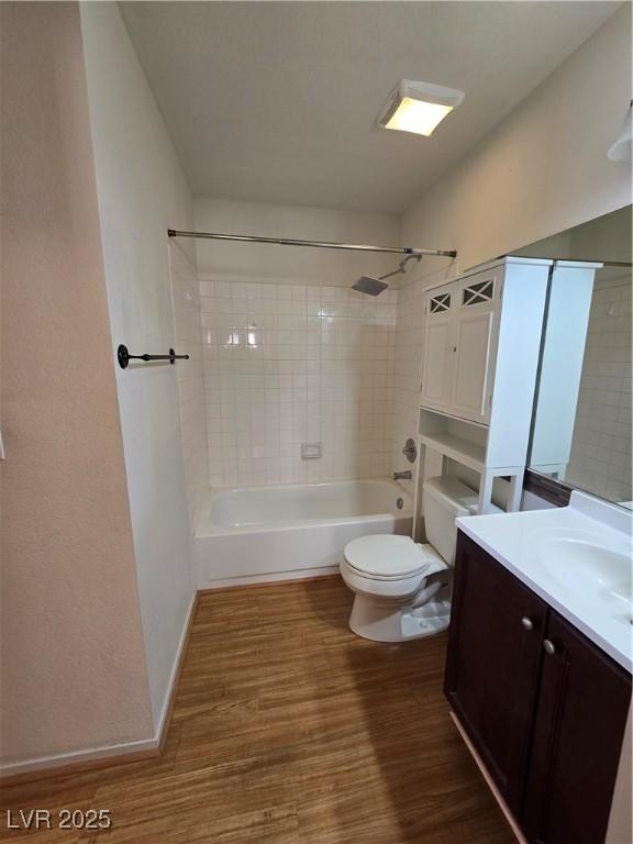 full bathroom with toilet, wood finished floors, vanity, and tub / shower combination