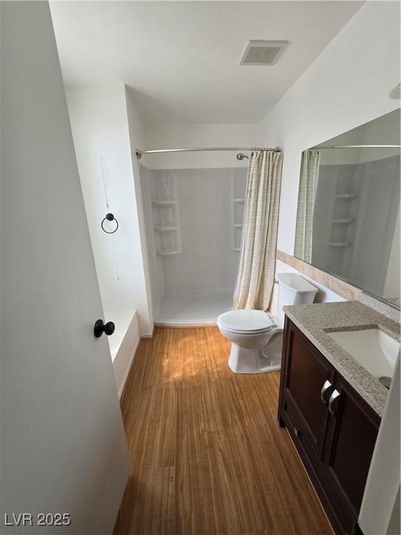 full bathroom featuring visible vents, curtained shower, toilet, vanity, and wood finished floors