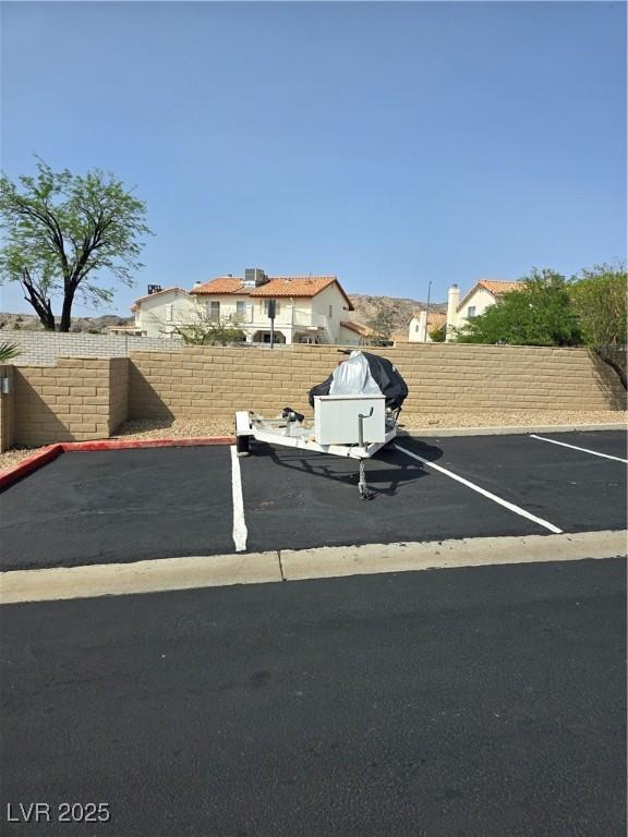 uncovered parking lot featuring a fenced backyard