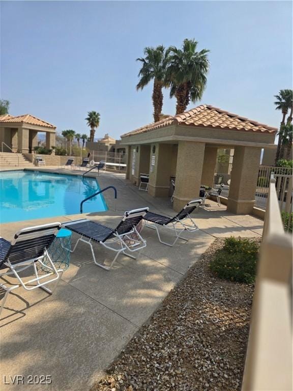 pool with a patio area and fence