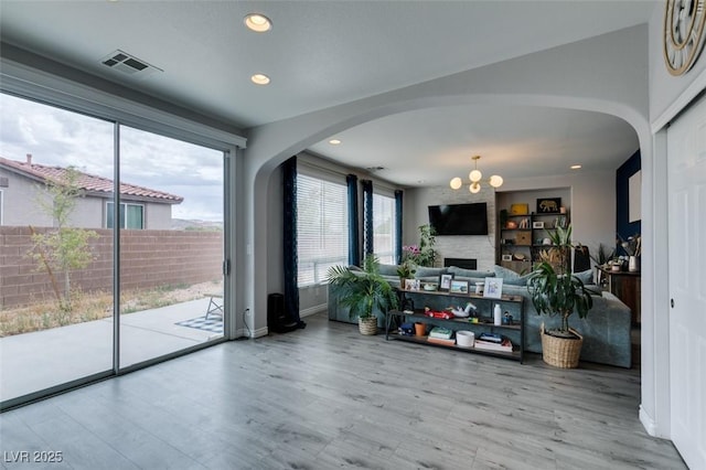 11769 Via Vera Cruz Ct, Las Vegas, NV 89138 - living room featuring arched walkways, plenty of natural light, a chandelier, wood finished floors, and recessed lighting