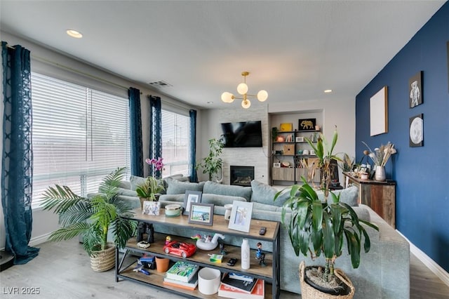 11769 Via Vera Cruz Ct, Las Vegas, NV 89138 - living area with baseboards, a large fireplace, and a chandelier