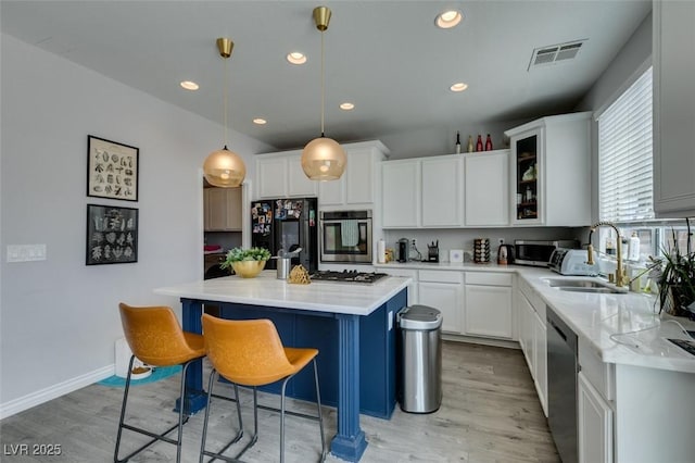 11769 Via Vera Cruz Ct, Las Vegas, NV 89138 - kitchen with appliances with stainless steel finishes, a sink, light wood-type flooring, a breakfast bar area, and recessed lighting