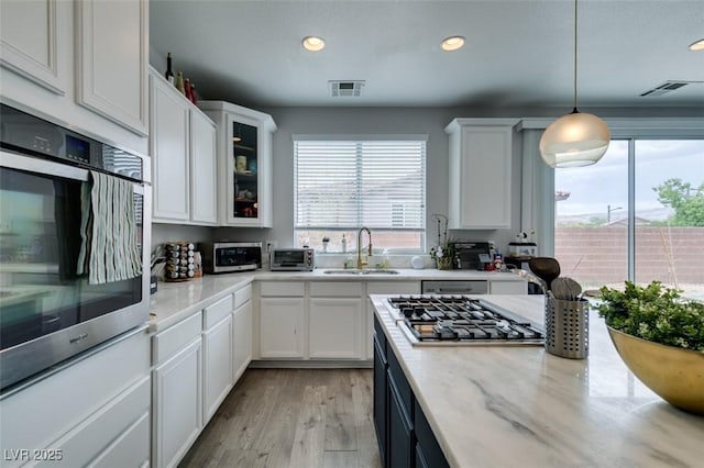 11769 Via Vera Cruz Ct, Las Vegas, NV 89138 - kitchen with a sink, plenty of natural light, white cabinets, stainless steel appliances, and recessed lighting