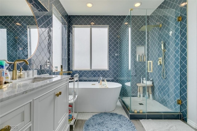 11769 Via Vera Cruz Ct, Las Vegas, NV 89138 - full bathroom with tile walls, a stall shower, a freestanding tub, vanity, and wood finished floors