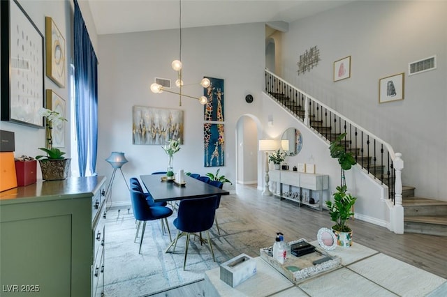 11769 Via Vera Cruz Ct, Las Vegas, NV 89138 - dining space with arched walkways, stairway, high vaulted ceiling, wood finished floors, and baseboards