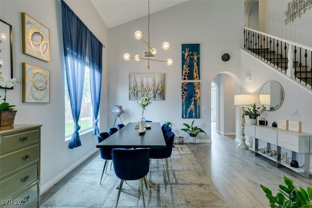 11769 Via Vera Cruz Ct, Las Vegas, NV 89138 - dining area with high vaulted ceiling, arched walkways, wood finished floors, baseboards, and a chandelier