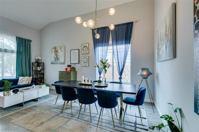 11769 Via Vera Cruz Ct, Las Vegas, NV 89138 - dining area with lofted ceiling, healthy amount of natural light, wood finished floors, a chandelier, and baseboards