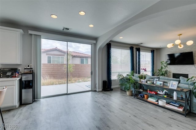 11769 Via Vera Cruz Ct, Las Vegas, NV 89138 - living area with healthy amount of natural light, light wood-style floors, recessed lighting, arched walkways, and a fireplace