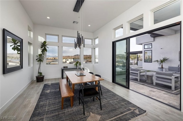 148 Tre Pietre St, Henderson, NV 89011 - dining area with wood finished floors, a towering ceiling, baseboards, and recessed lighting