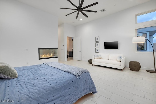 148 Tre Pietre St, Henderson, NV 89011 - bedroom with a glass covered fireplace, baseboards, recessed lighting, visible vents, and ceiling fan