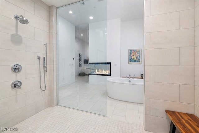 148 Tre Pietre St, Henderson, NV 89011 - bathroom with a glass covered fireplace, recessed lighting, tile patterned floors, tiled shower, and a freestanding bath