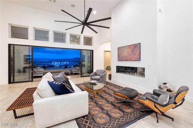 148 Tre Pietre St, Henderson, NV 89011 - living area with baseboards, ceiling fan, recessed lighting, wood finished floors, and a glass covered fireplace