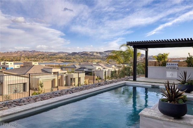 148 Tre Pietre St, Henderson, NV 89011 - view of swimming pool with a fenced in pool, a residential view, a mountain view, an outdoor kitchen, and a fenced backyard