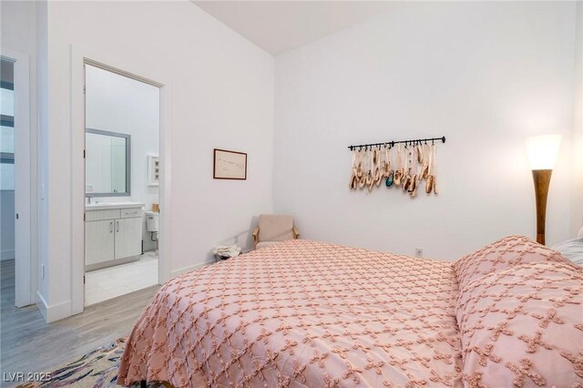 148 Tre Pietre St, Henderson, NV 89011 - bedroom featuring light wood-style floors, baseboards, a sink, and connected bathroom