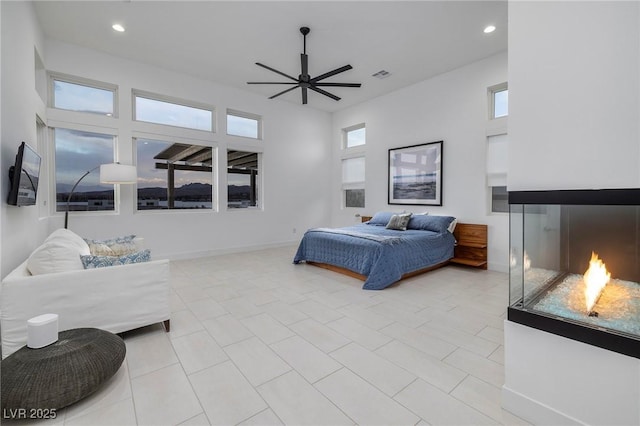 148 Tre Pietre St, Henderson, NV 89011 - bedroom featuring visible vents, recessed lighting, a glass covered fireplace, and light tile patterned floors